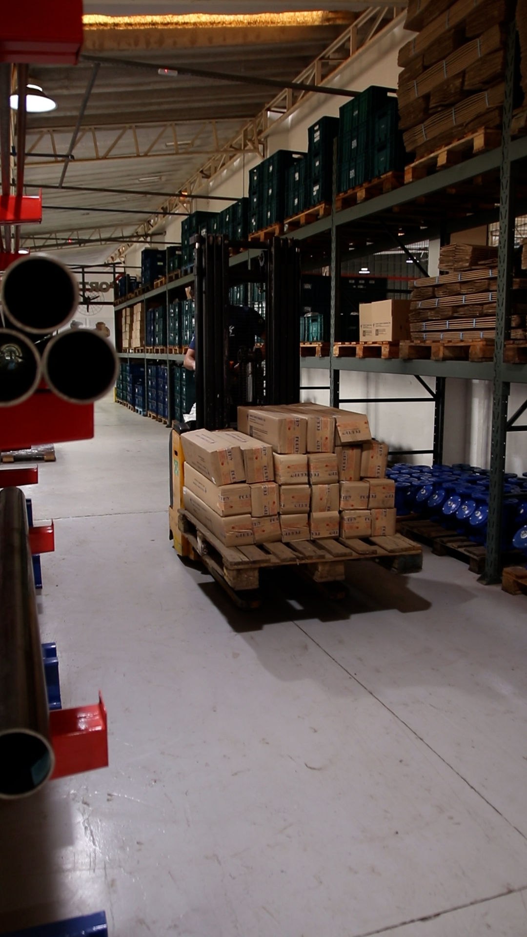 Funcionário operando empilhadeira para transportar um palete de caixas Forthy pelo galpão, a caminho da expedição