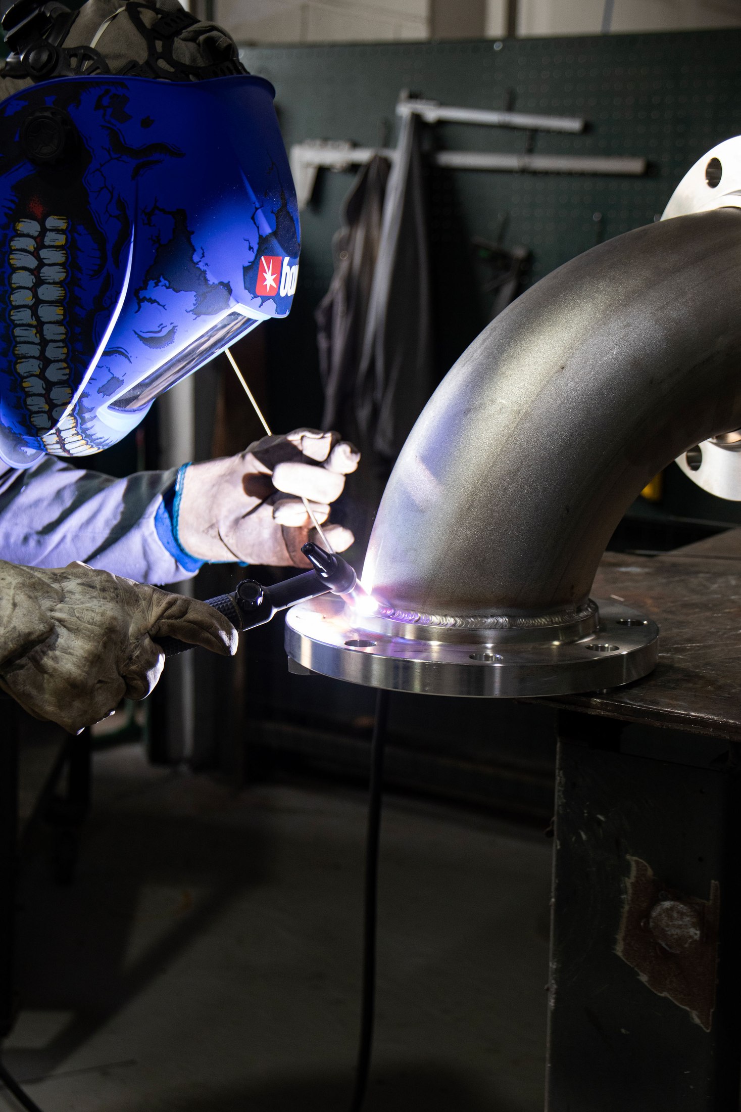 Funcionário da Forthy soldando um flange em tubo de aço inox de grande diâmetro, na fábrica em Porto Feliz/SP